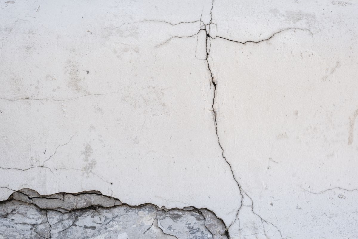 Revoco desprendido junto a una grieta vertical en una pared, señal de deterioro avanzado